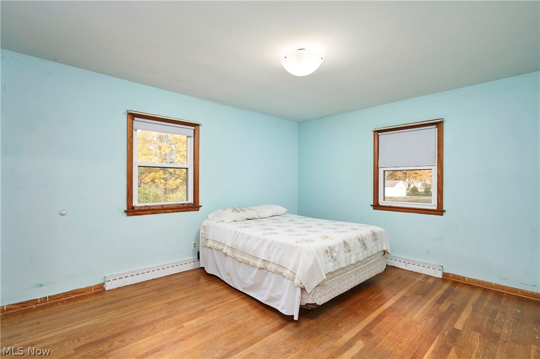 2941 Sweitzer Road Uniontown, OH 44685 - Photo 9 of 16 Bedroom with baseboard heating and wood finished floors