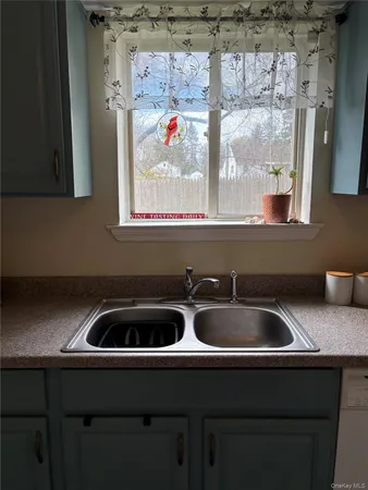 a kitchen with a sink and a stove next to a window