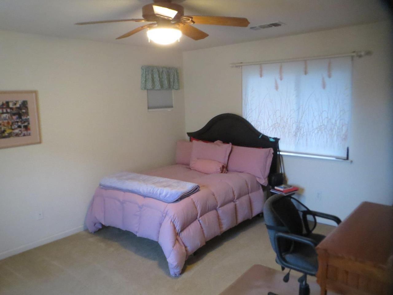 4125 Pathway Lane Turlock, CA 95382 - Photo 13 of 15 a bedroom with a bed and a chandelier