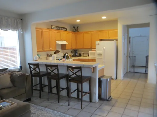 a kitchen with stainless steel appliances a table chairs and a refrigerator