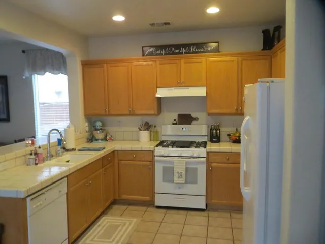 a kitchen with a sink a stove a refrigerator and cabinets