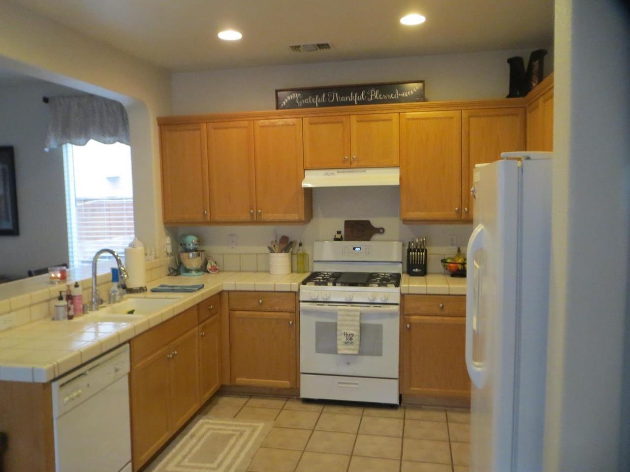4125 Pathway Lane Turlock, CA 95382 - Photo 5 of 15 a kitchen with a sink a stove a refrigerator and cabinets