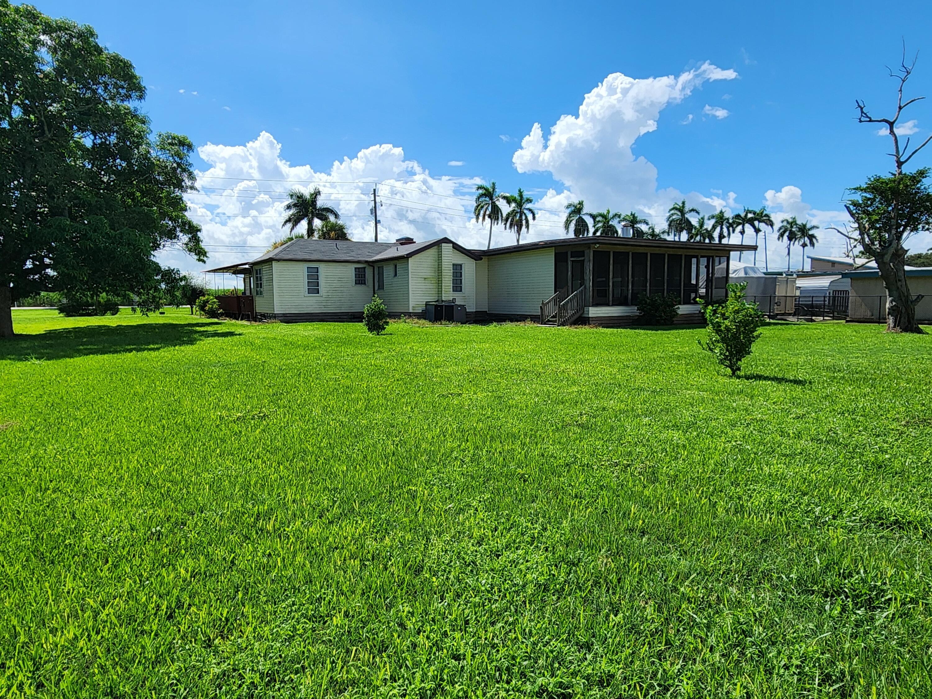 2727 Bacom Point Road Pahokee, FL 33476 - Photo 11 of 34 a front view of a house with garden