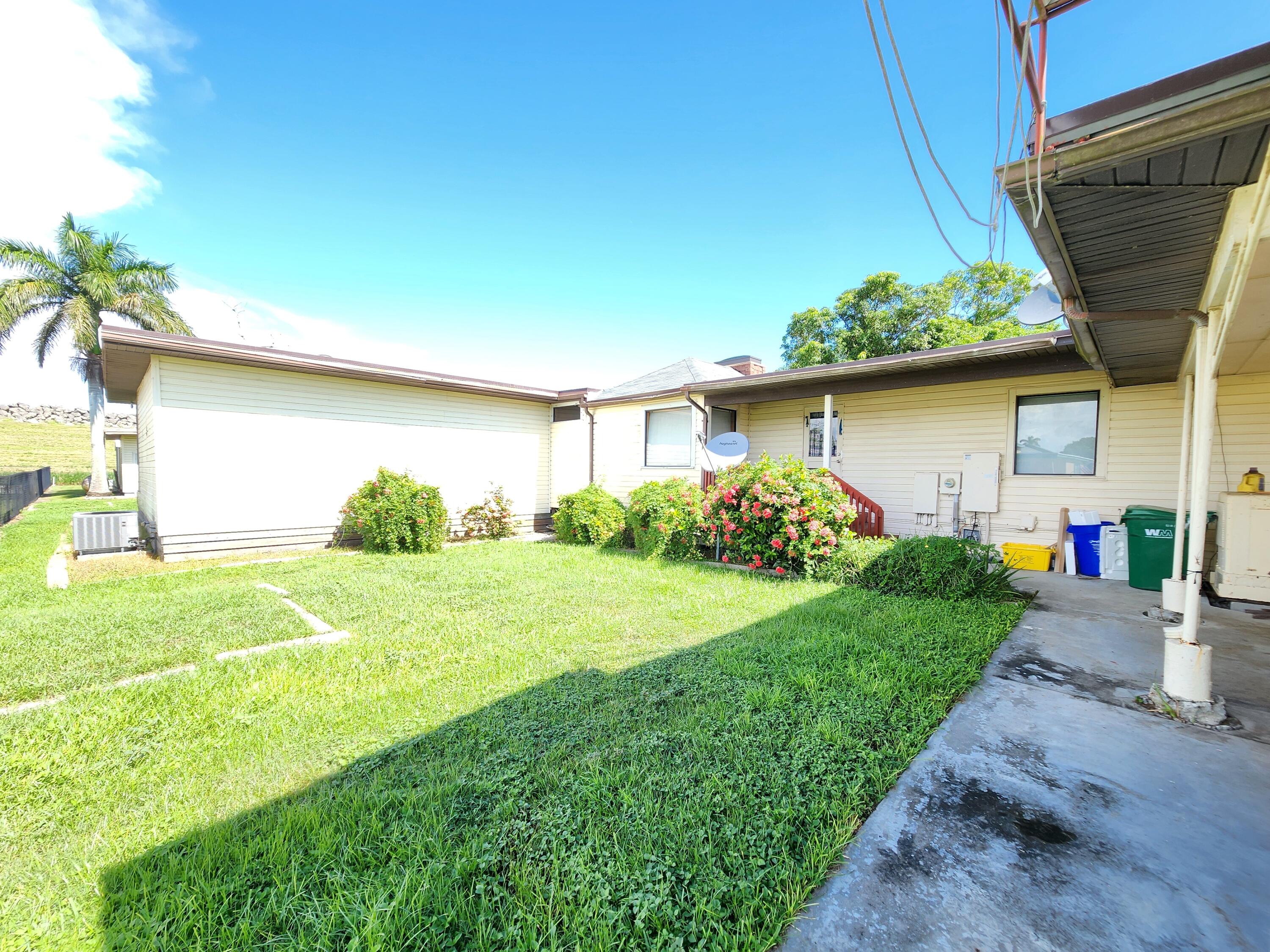 2727 Bacom Point Road Pahokee, FL 33476 - Photo 8 of 34 a front view of a house with garden