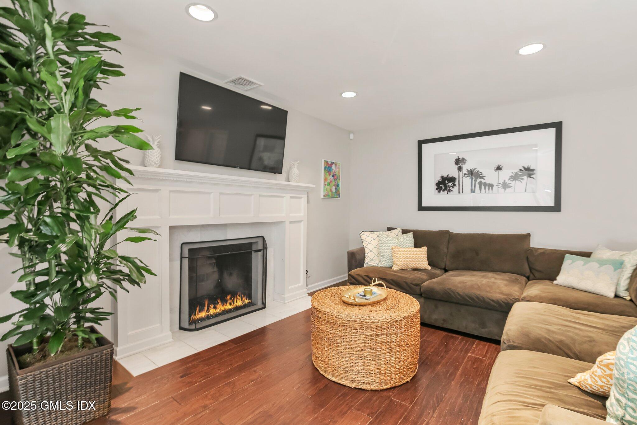 16 Split Timber Place Riverside, CT 06878 - Photo 17 of 34 a living room with furniture a fireplace and a flat screen tv