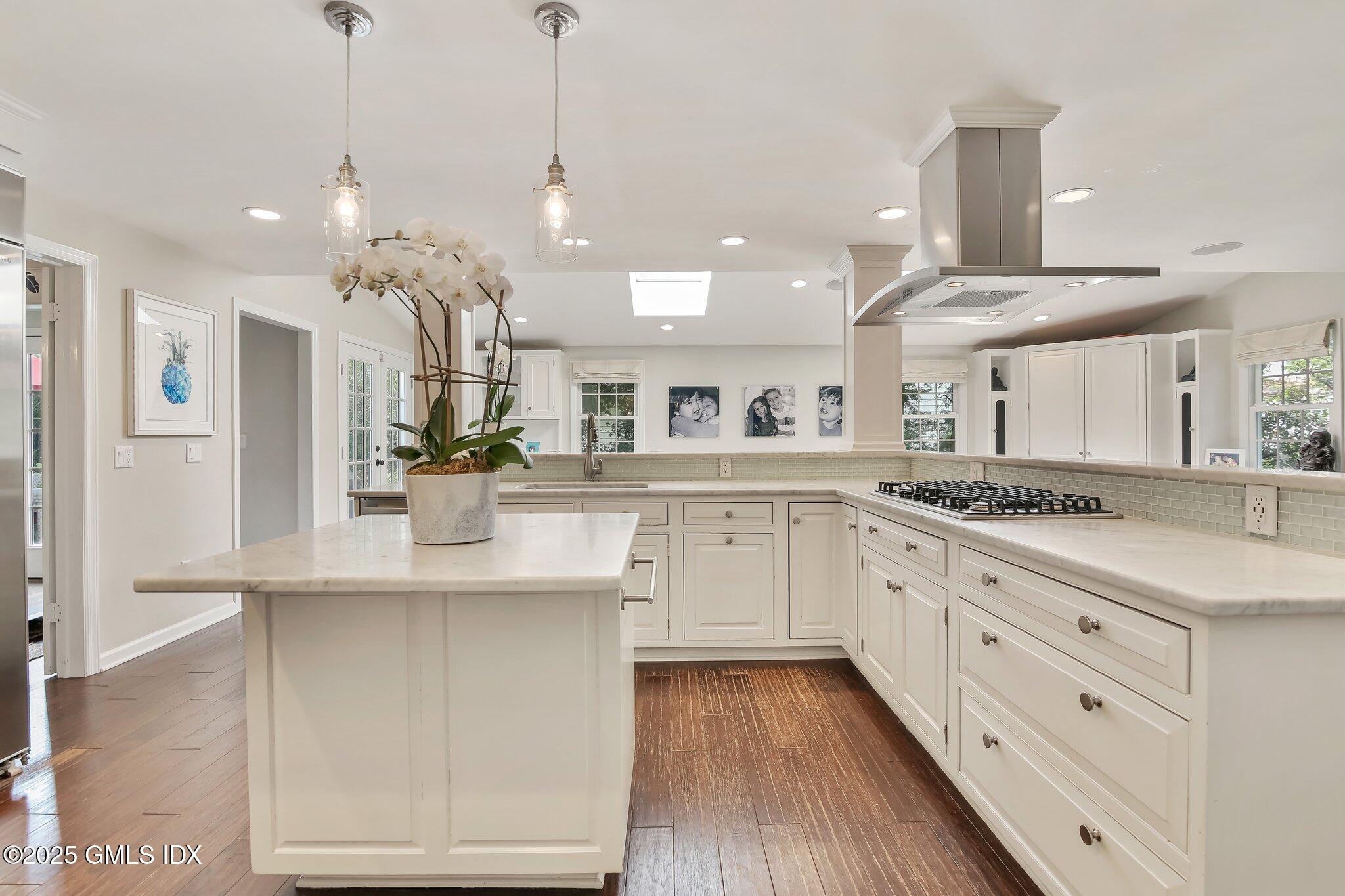 16 Split Timber Place Riverside, CT 06878 - Photo 10 of 34 a kitchen with stainless steel appliances kitchen island granite countertop a refrigerator a sink dishwasher a oven and white cabinets with wooden floor