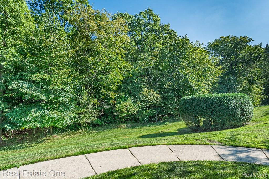 3491 Tremonte Circle Rochester, MI 48306 - Photo 37 of 42 Manicured lawn with a concrete pathway and mature trees