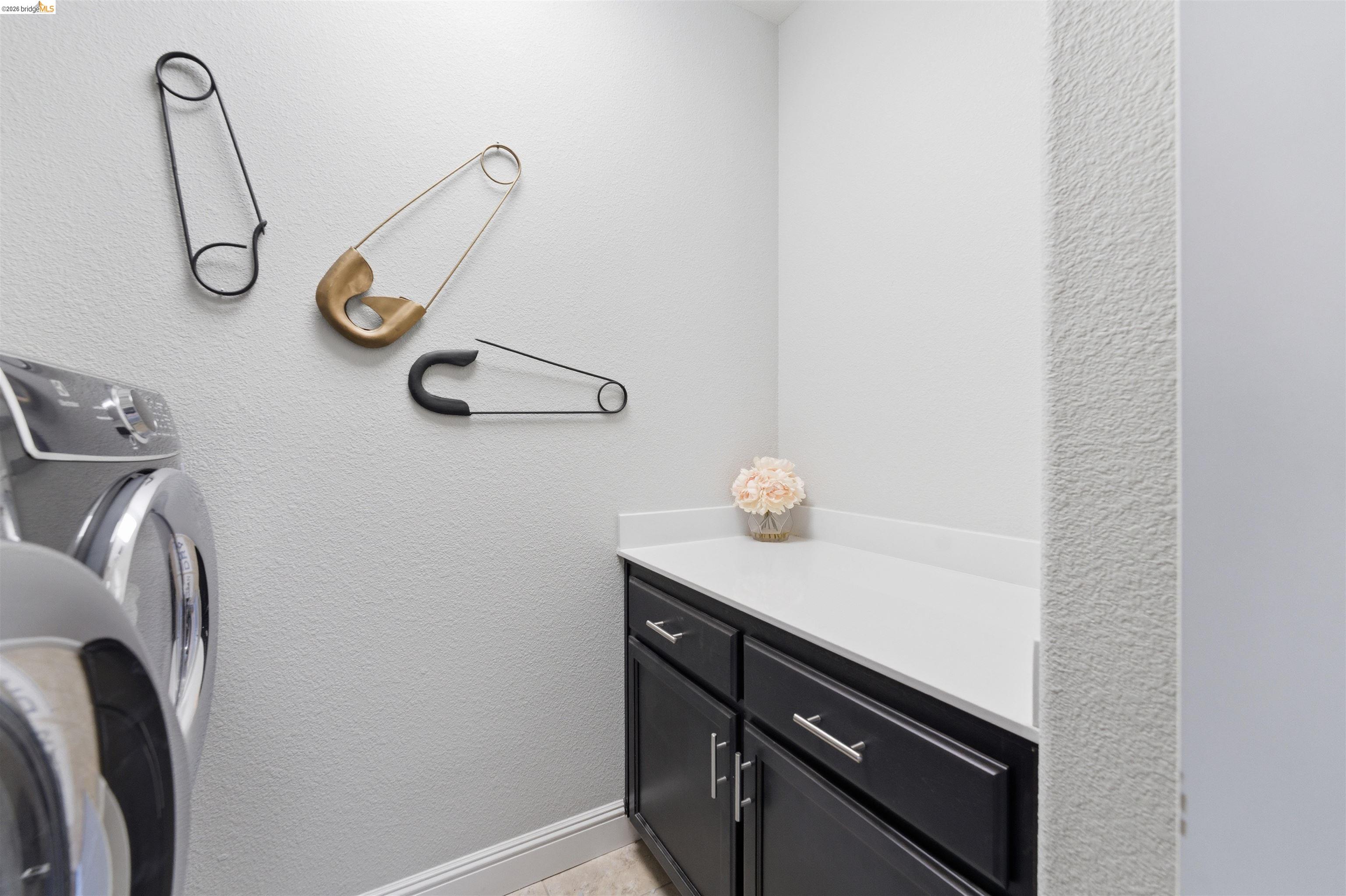 72 Greystone Place Pittsburg, CA 94565 - Photo 32 of 41 a close view of light fixtures and utility room with washer and dryer