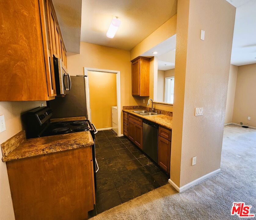 375 Central Avenue, Unit 165 Riverside, CA 92507 - Photo 5 of 24 a kitchen with stainless steel appliances granite countertop a stove a sink and a refrigerator