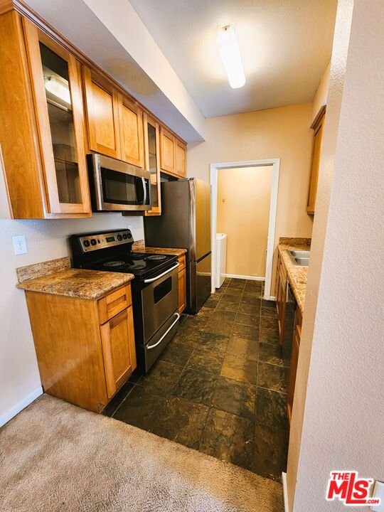 375 Central Avenue, Unit 165 Riverside, CA 92507 - Photo 6 of 24 a kitchen with stainless steel appliances granite countertop a stove a sink and a refrigerator