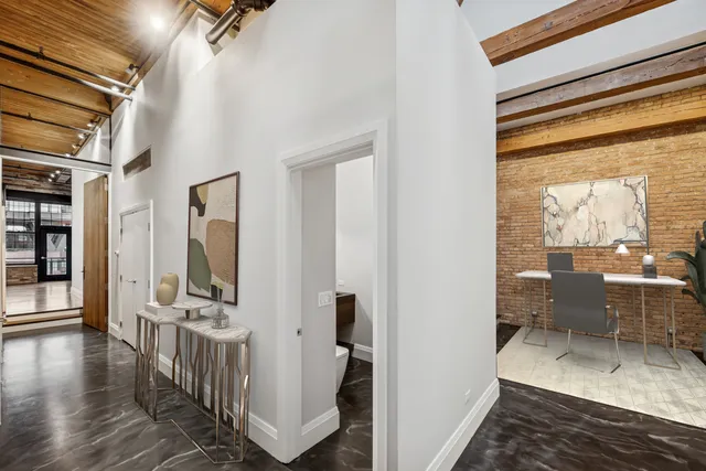a view of a hallway with living room and wooden floor