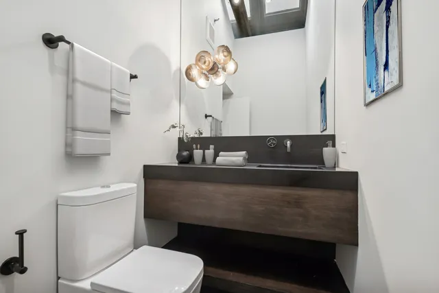 a bathroom with a sink a toilet and a mirror