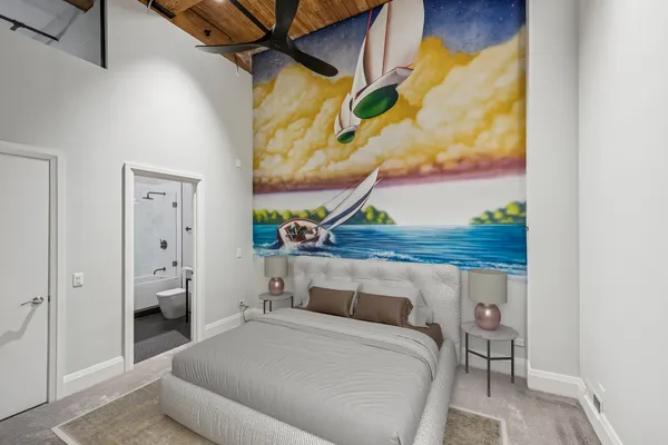 a bedroom with a bed and a painting on the wall