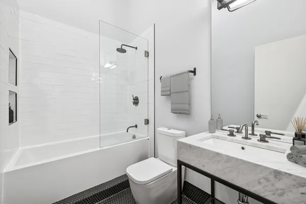 a bathroom with a sink toilet vanity and shower