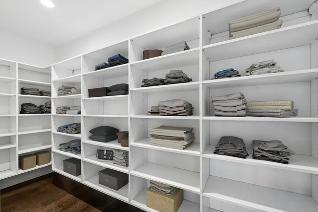 a view of walk in closet with clothes and shoes