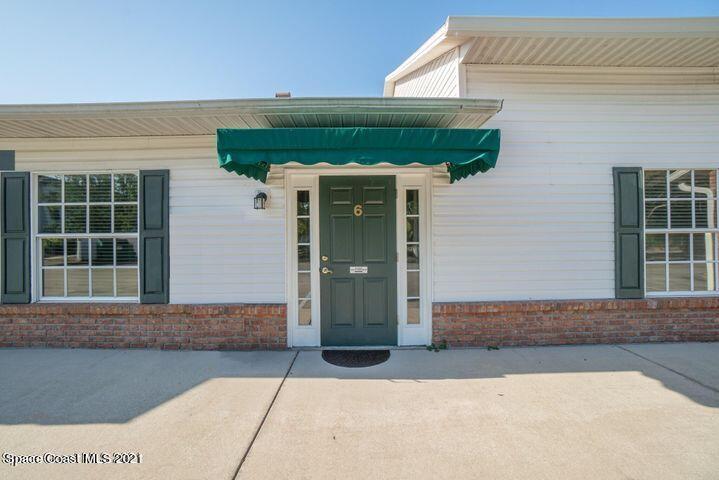 3200 North Wickham Road, Unit 56 Melbourne, FL 32935 - Photo 3 of 28 a front view of a house with a yard