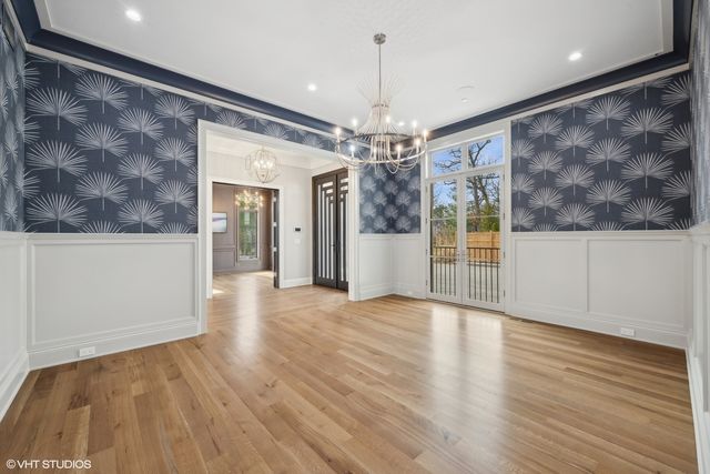a view of a livingroom with wooden floor and chandelier
