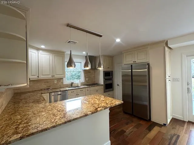 a kitchen with stainless steel appliances granite countertop a refrigerator and a sink