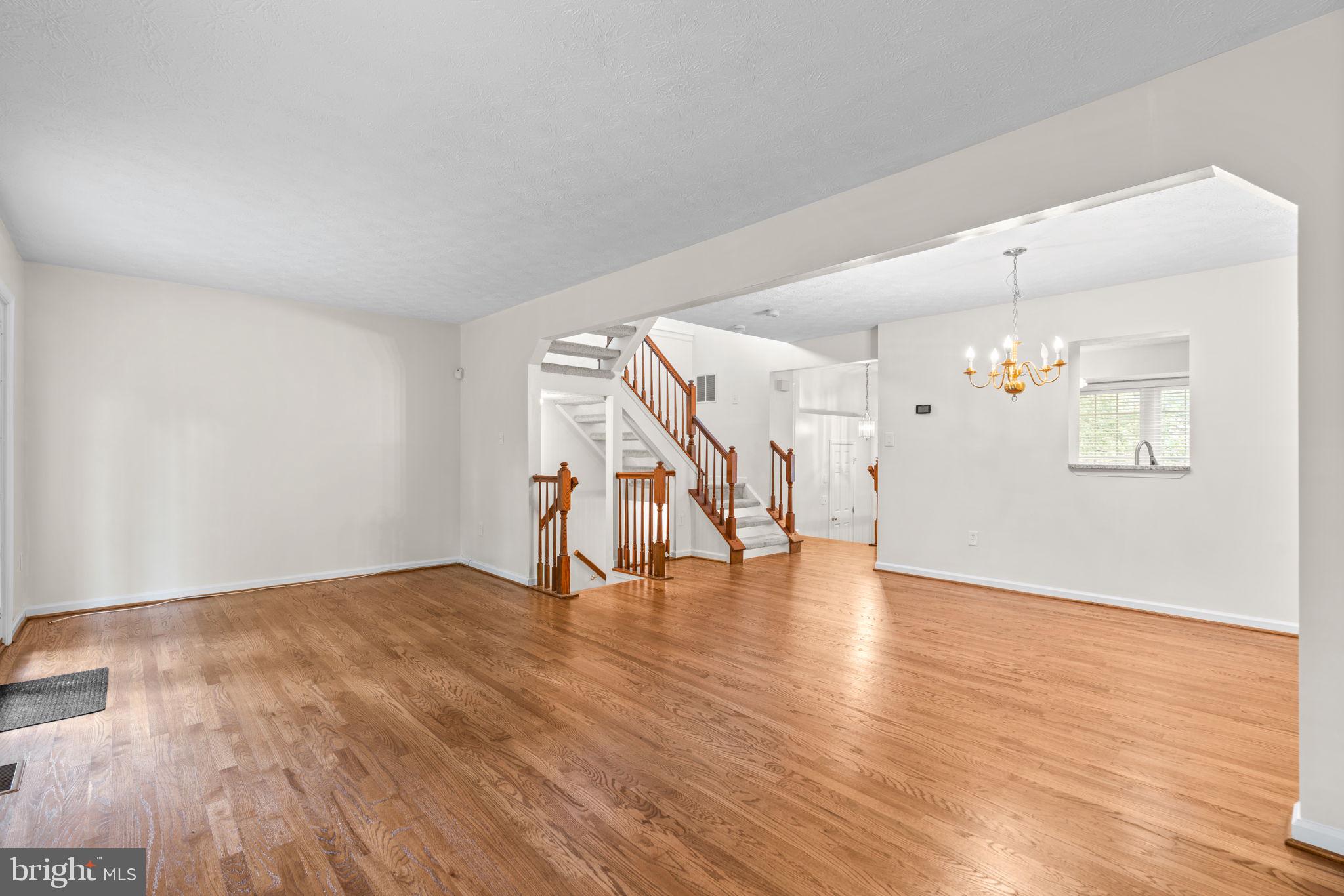 5646 April Journey, Unit 50 Columbia, MD 21044 - Photo 12 of 32 a view of an empty room with wooden floor and stairs