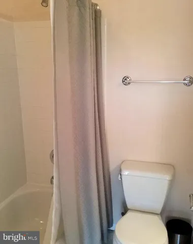 a white toilet sitting next to a bath tub
