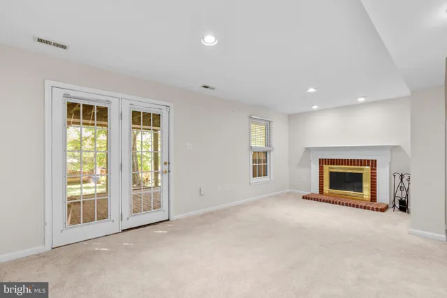 an empty room with windows and fireplace