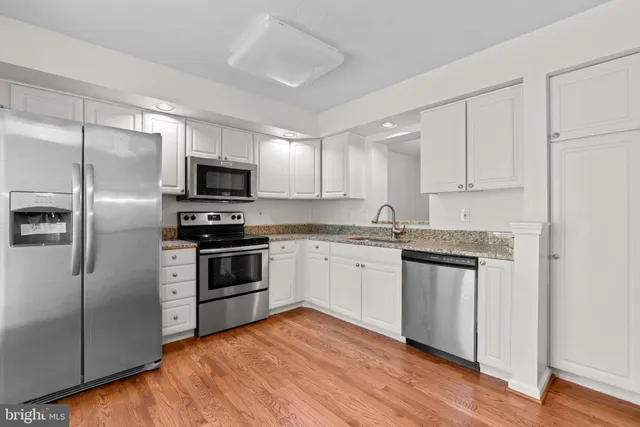 a kitchen with granite countertop a refrigerator and a sink