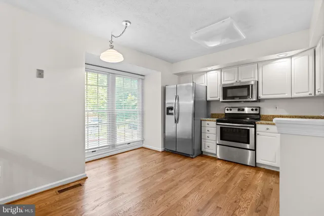 a kitchen with granite countertop a stove and a refrigerator