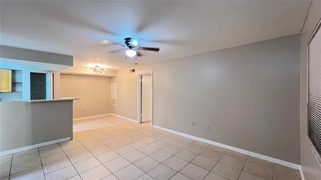 a view of an empty room and chandelier fan