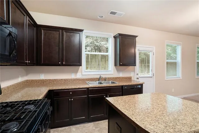 a kitchen with granite countertop cabinets sink and window