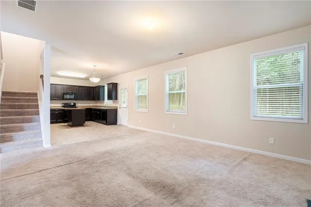 a view of kitchen with stainless steel appliances kitchen area and windows
