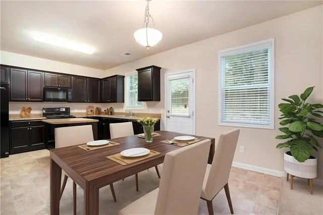 a kitchen with a table chairs microwave and cabinets