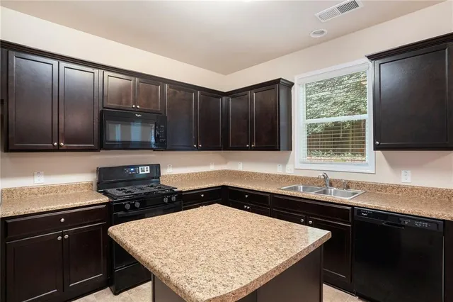 a kitchen with granite countertop cabinets a sink and a stove