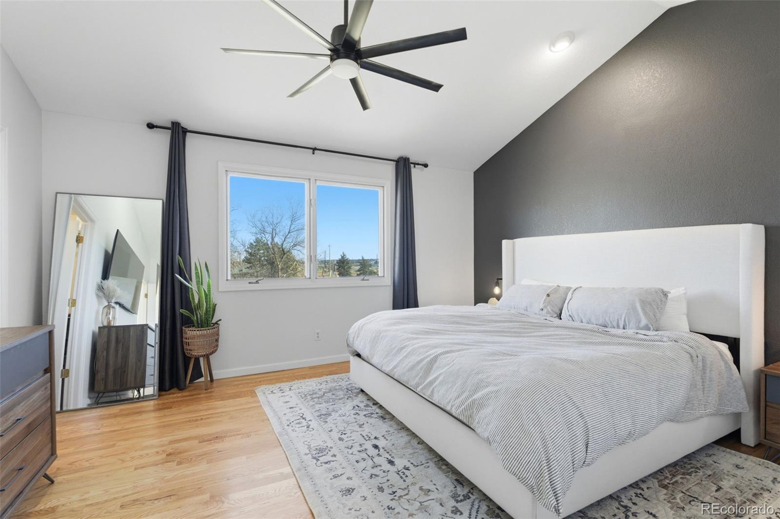4418 Fig Street Golden, CO 80403 - Photo 19 of 50 a bedroom with a large bed and a chandelier