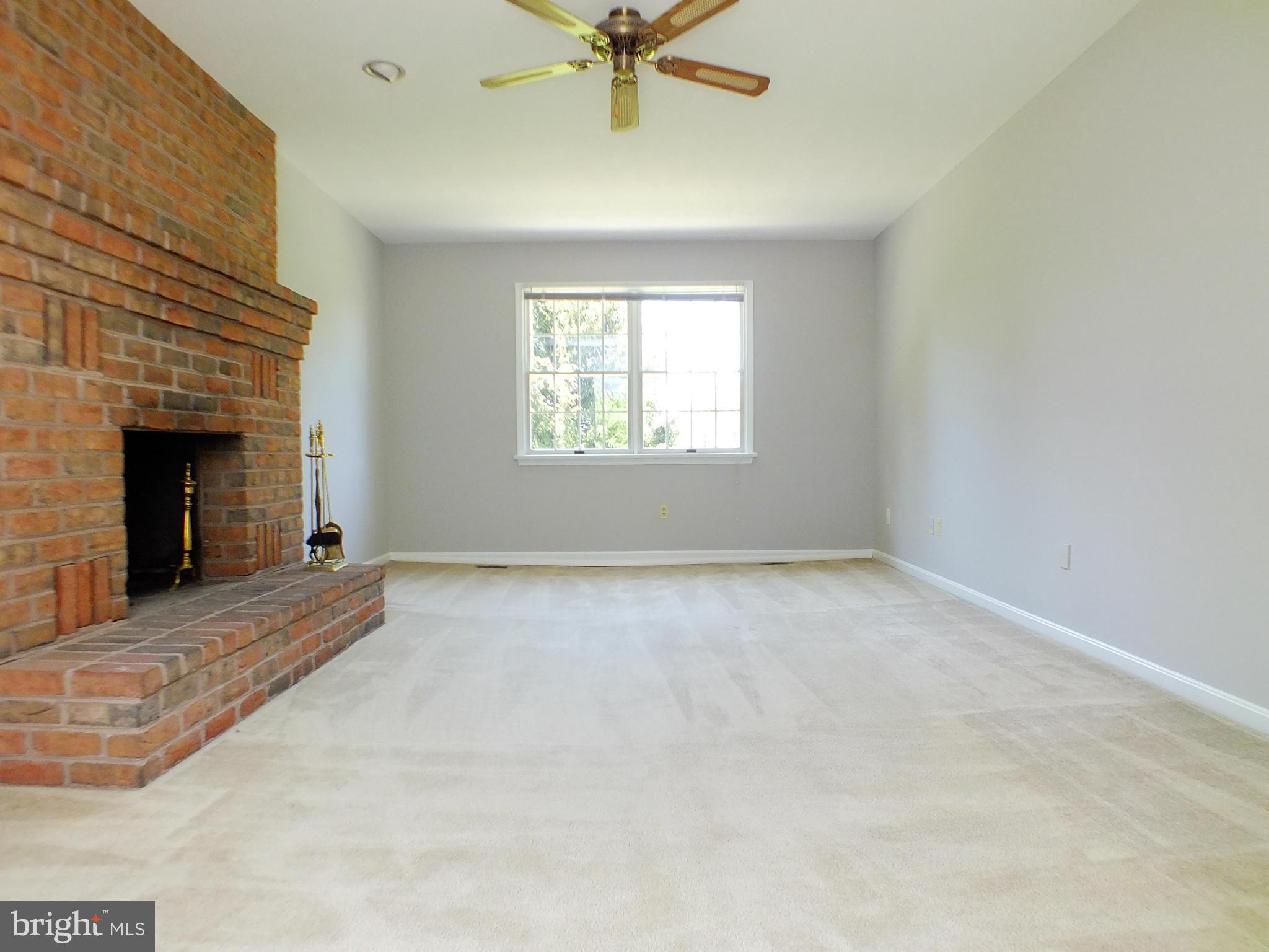 18249 Falls Road Hampstead, MD 21074 - Photo 11 of 30 an empty room with windows and fireplace