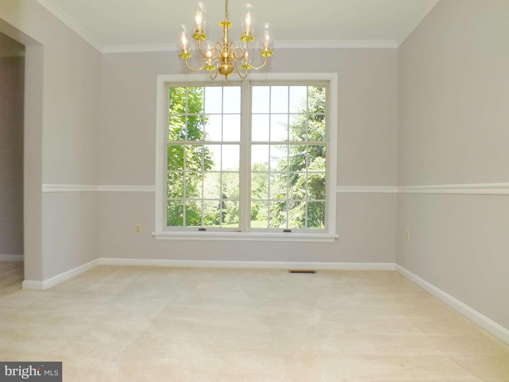 18249 Falls Road Hampstead, MD 21074 - Photo 6 of 30 an empty room with a windows and chandelier