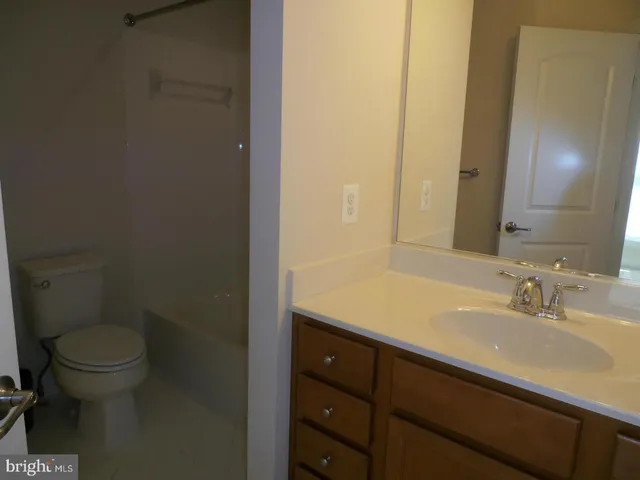 a bathroom with a sink a toilet a mirror and vanity