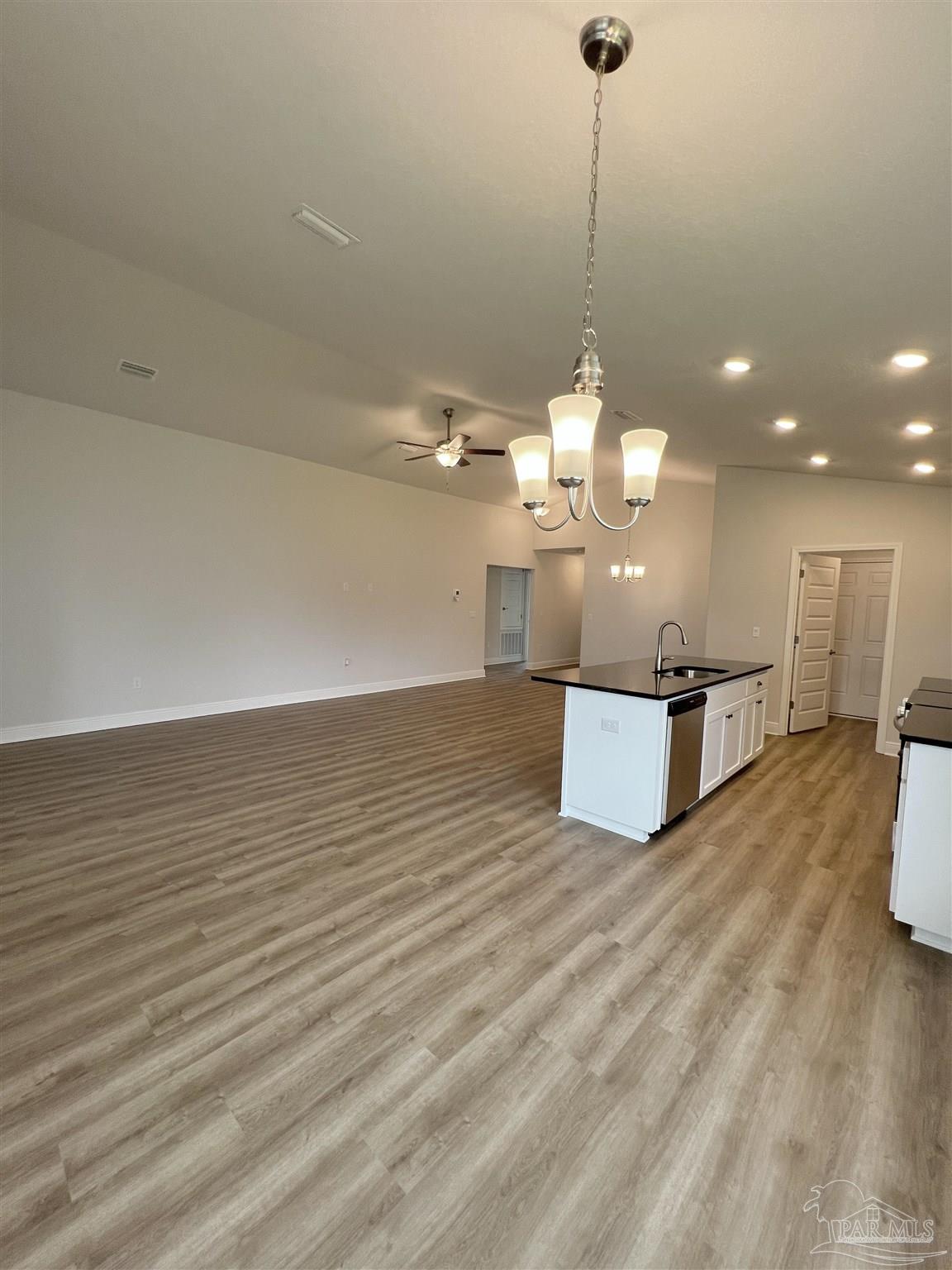 924 Rustling Pnes Road, Unit 17B Cantonment, FL 32533 - Photo 4 of 12 a view of a room with kitchen island stainless steel appliances wooden floor and living room view