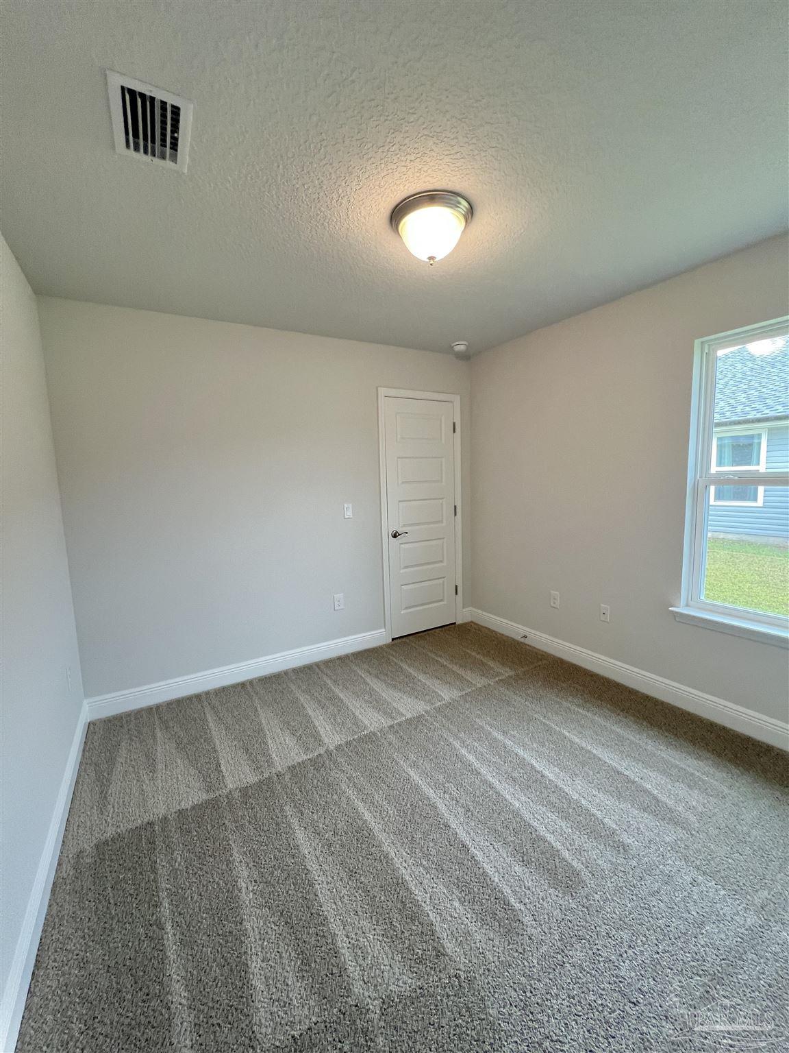924 Rustling Pnes Road, Unit 17B Cantonment, FL 32533 - Photo 6 of 12 an empty room with windows