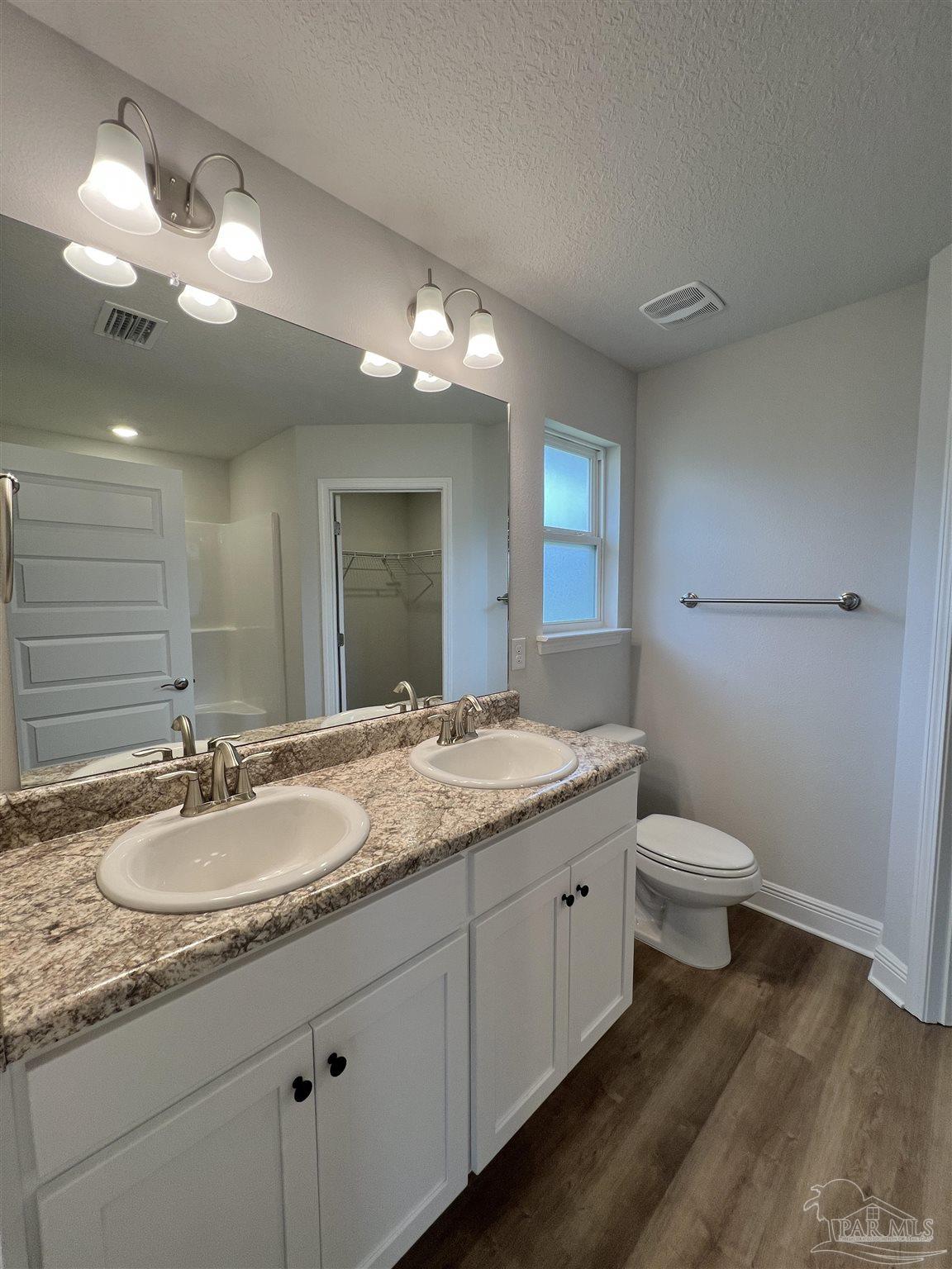 924 Rustling Pnes Road, Unit 17B Cantonment, FL 32533 - Photo 10 of 12 a bathroom with a granite countertop double vanity and a mirror