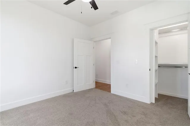 an empty room with a window and a ceiling fan