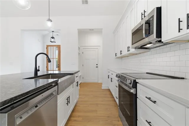 a kitchen with stainless steel appliances a sink stove and cabinets