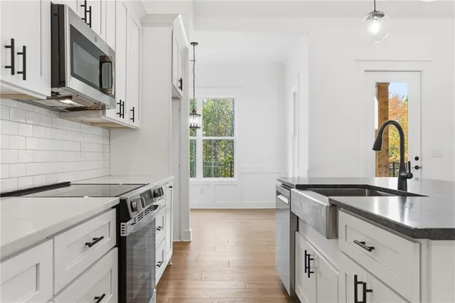 a kitchen with granite countertop a sink stainless steel appliances and cabinets