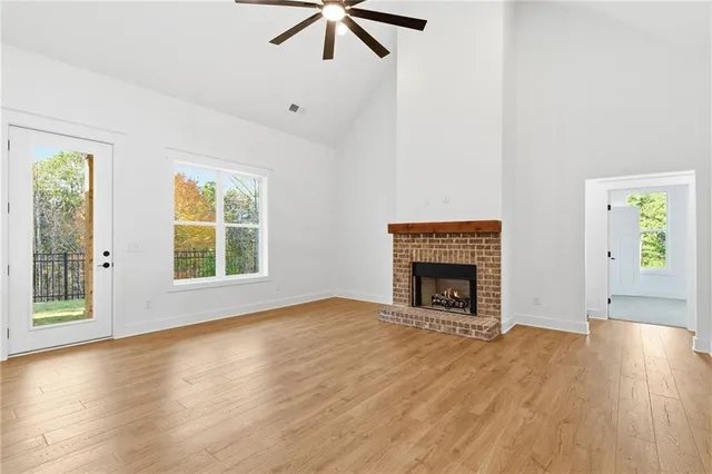 wooden floor fireplace and windows in an empty room