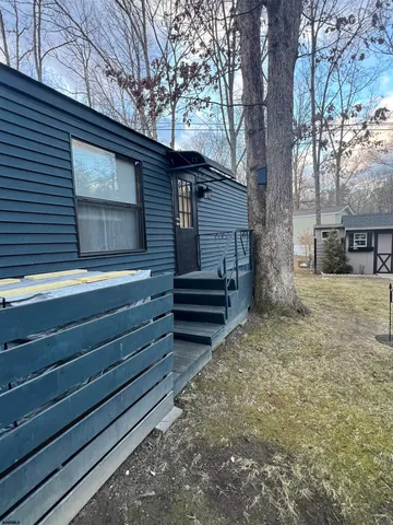 a backyard of a house with wooden fence and large trees