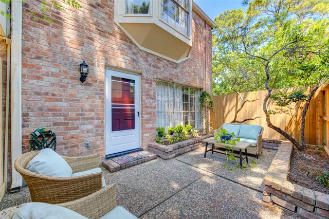 a view of a patio with couches table and chairs and potted plants