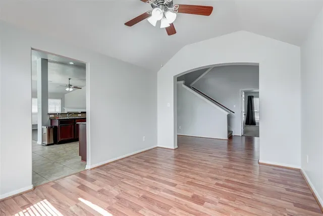 a view of a livingroom with wooden floor and a ceiling fan