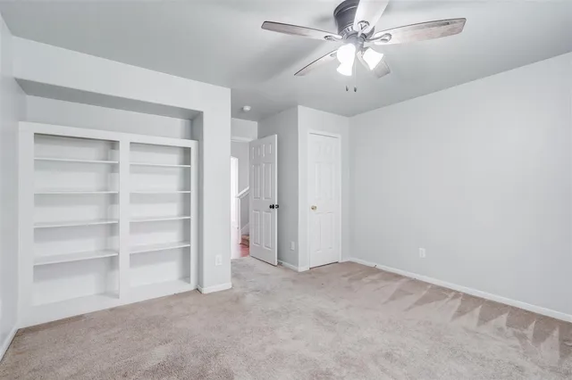 a view of an empty room and a ceiling fan