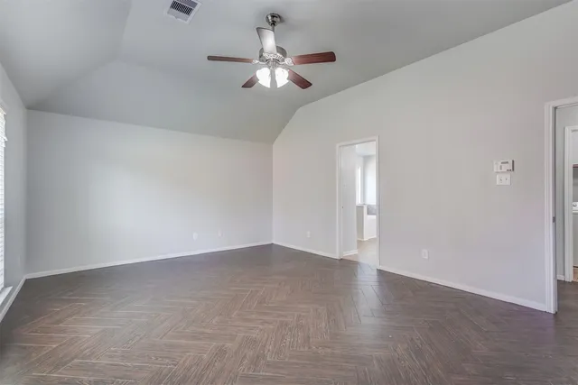 a view of an empty room with chandelier fan
