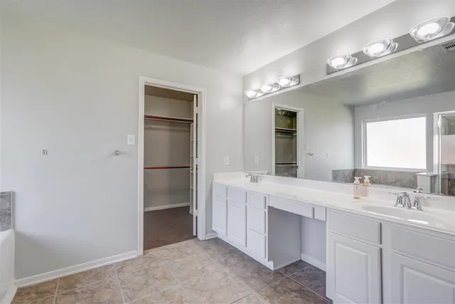 a bathroom with a double vanity sink and mirror