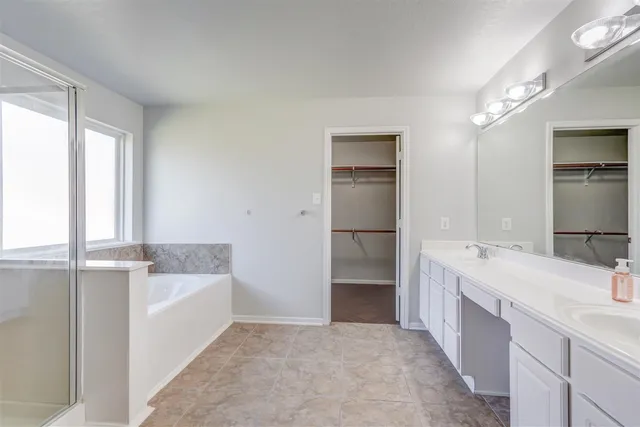 a bathroom with a tub sink and mirror